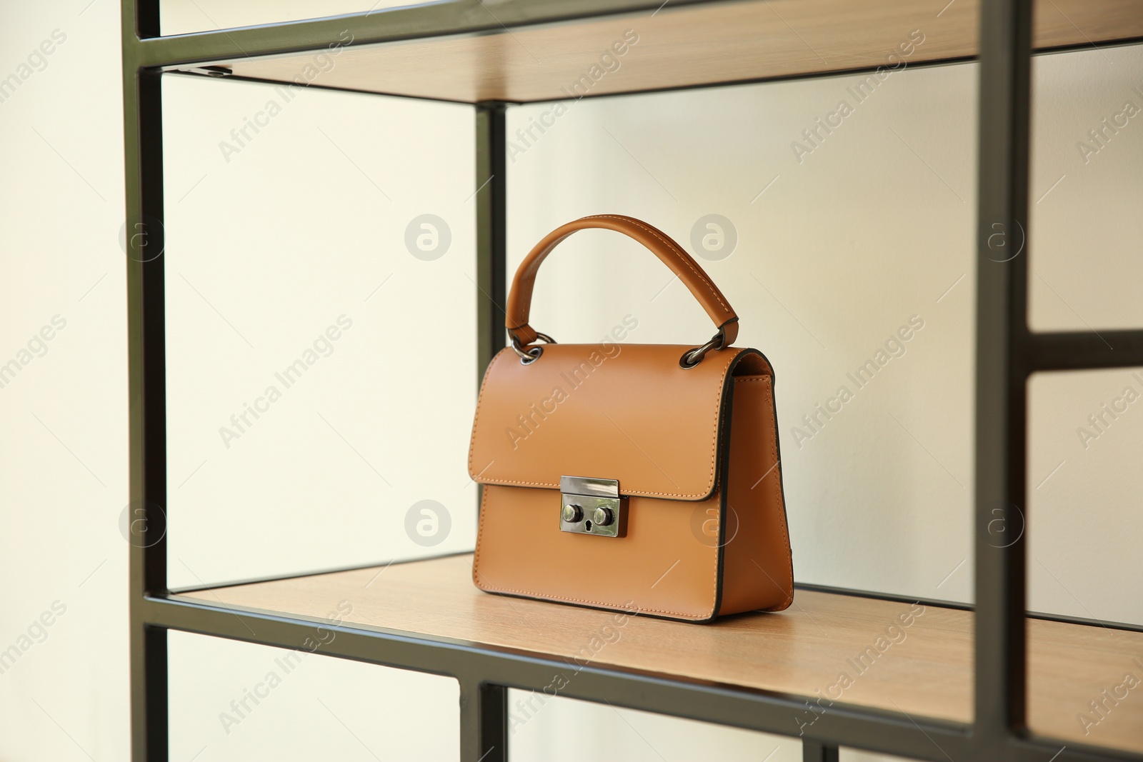 Photo of Stylish woman's bag on shelf in boutique