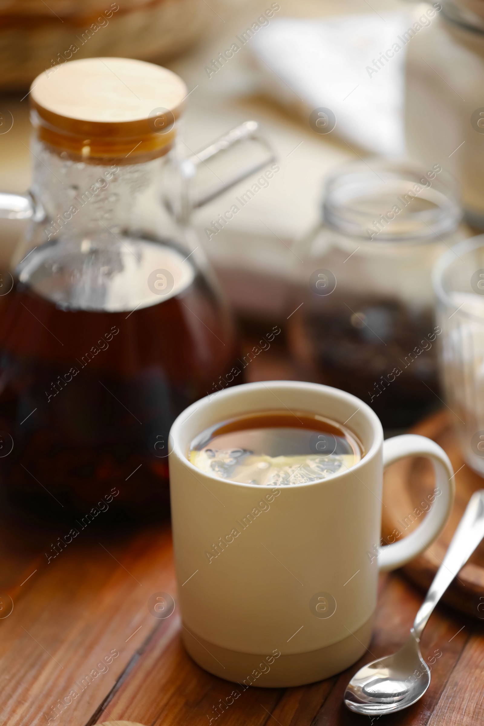 Photo of Cup of delicious tea with lemon on wooden table