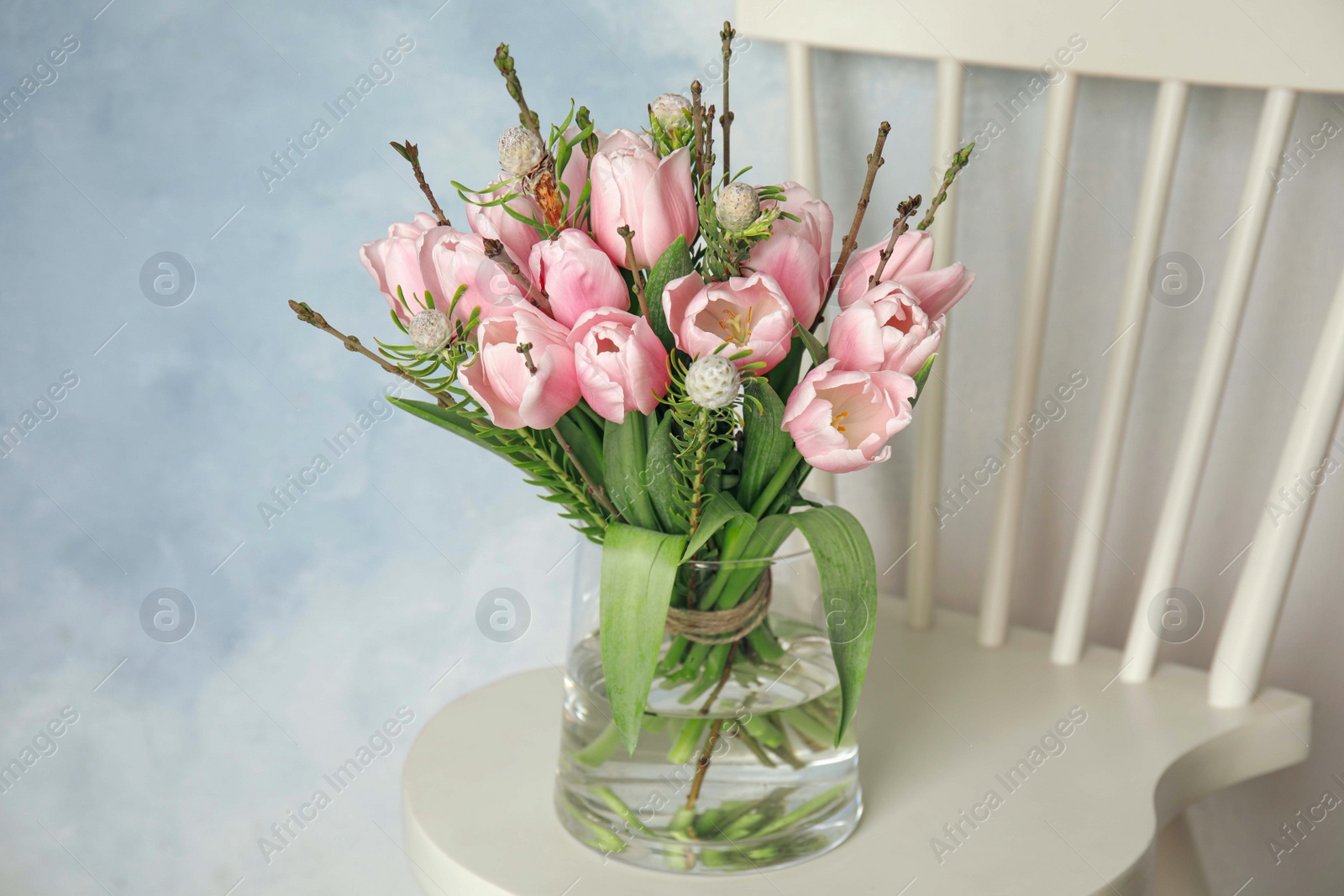 Photo of Beautiful bouquet with spring pink tulips on white chair