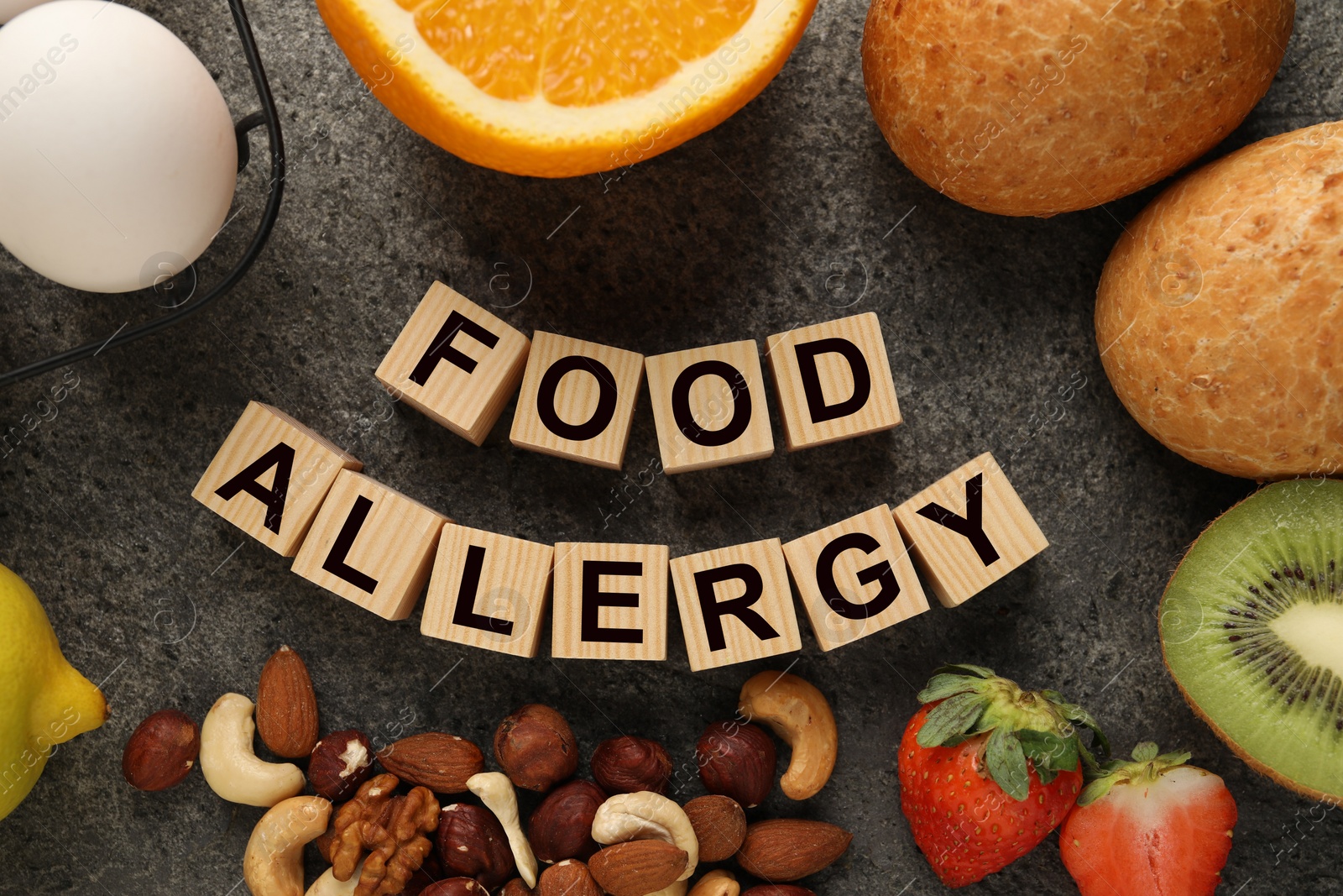 Image of Food allergy. Different fresh products and wooden cubes on grey table, flat lay