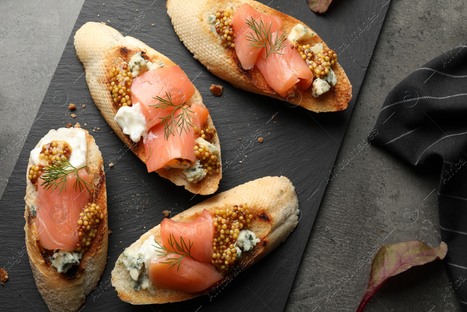 Photo of Flat lay composition with tasty bruschettas on grey table. Space for text