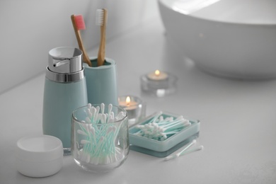 Photo of Cotton buds and toiletries on white countertop