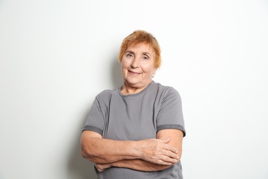 Portrait of elderly woman on light background