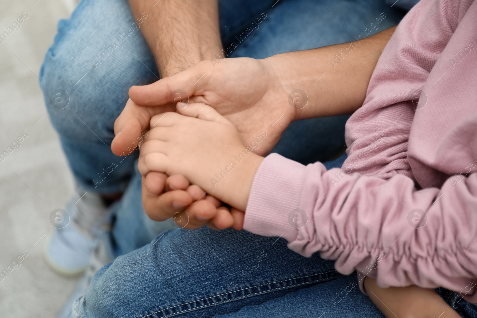 Photo of Closeup view of happy family holding hands