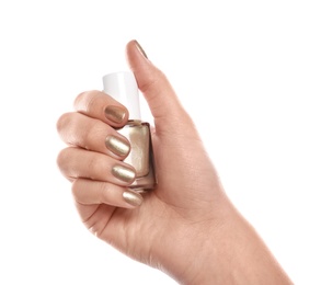 Photo of Woman with golden manicure holding nail polish bottle isolated on white, closeup