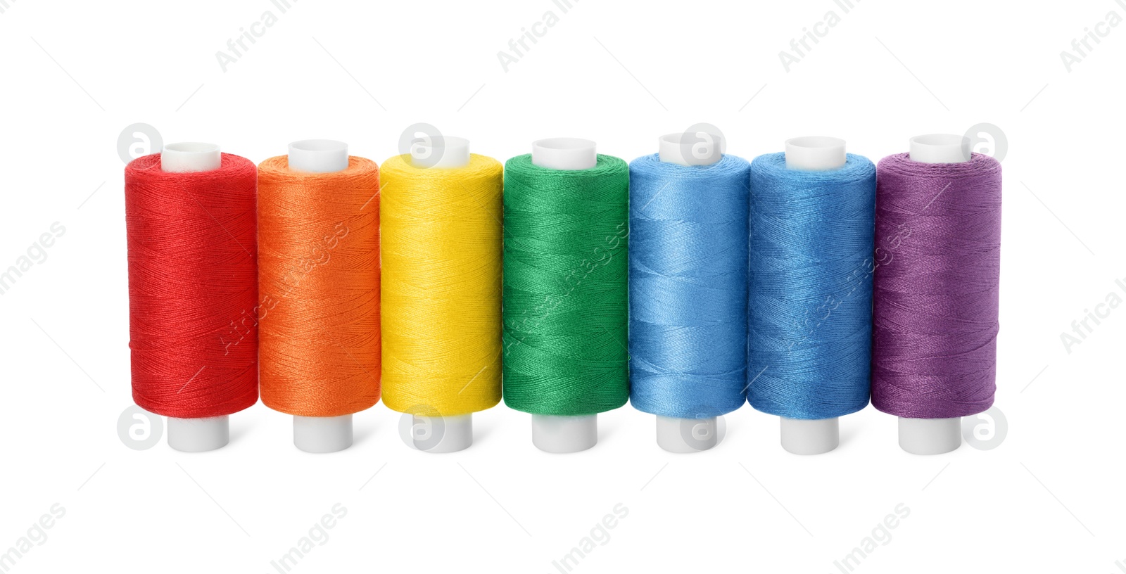 Photo of Set of different colorful sewing threads on white background