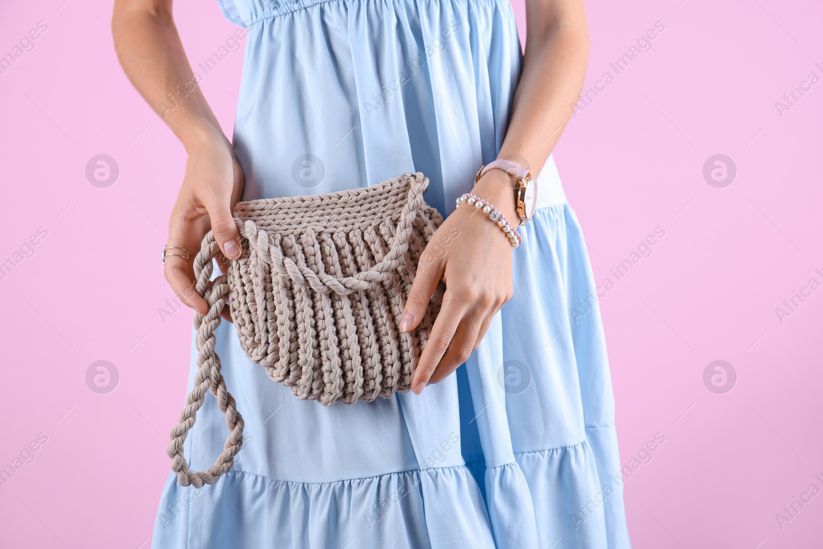 Photo of Young woman in stylish outfit with purse on color background, closeup