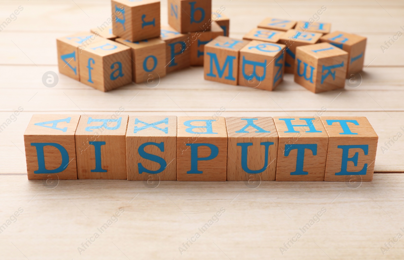 Photo of Cubes with word Dispute on light wooden table