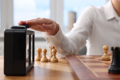 Photo of Woman turning on chess clock during tournament at table, closeup