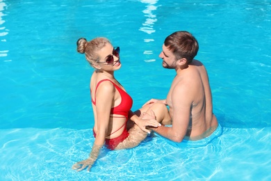 Happy young couple in swimming pool at resort