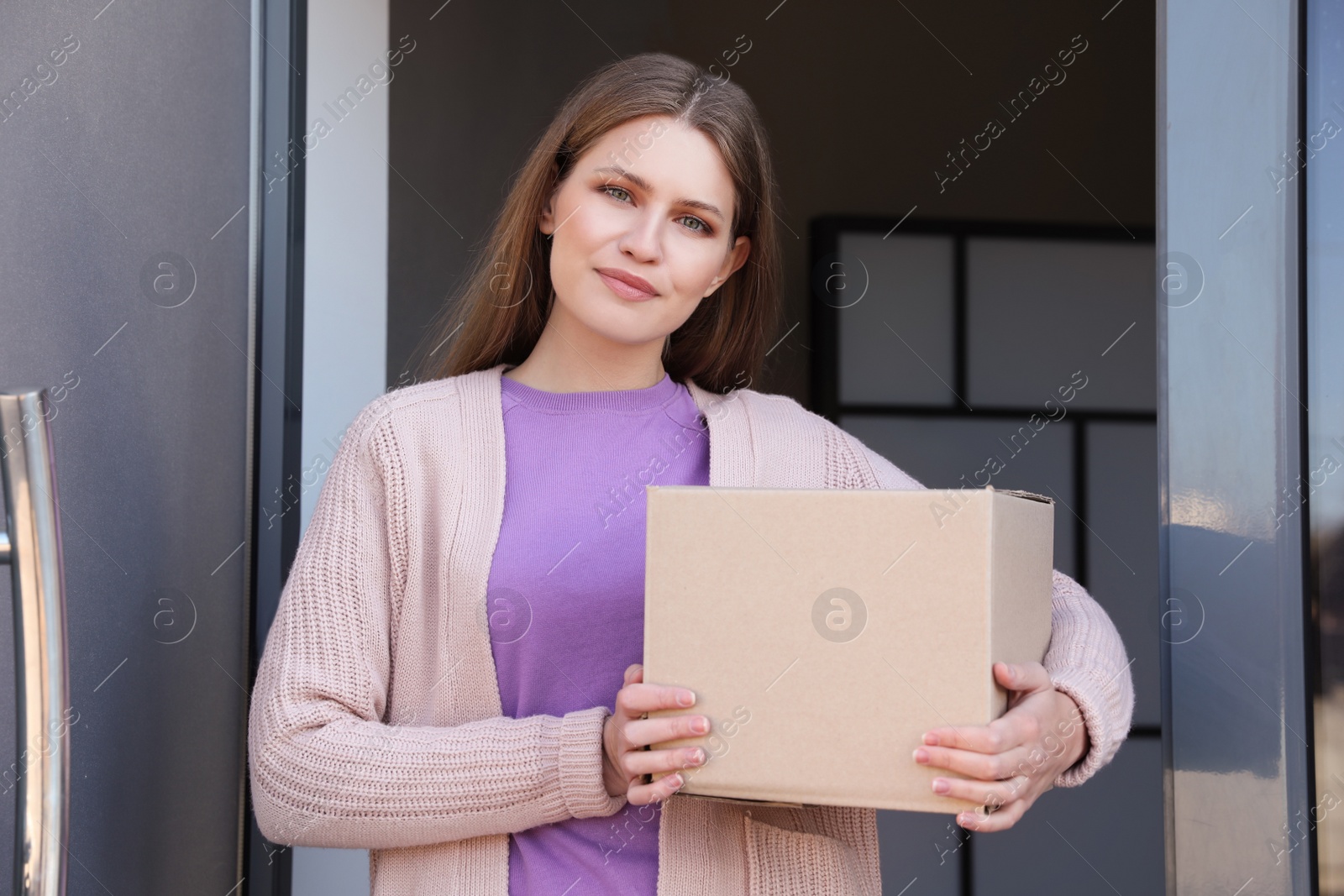 Photo of Portrait of smiling woman with parcel at door, mockup for design. Delivery service