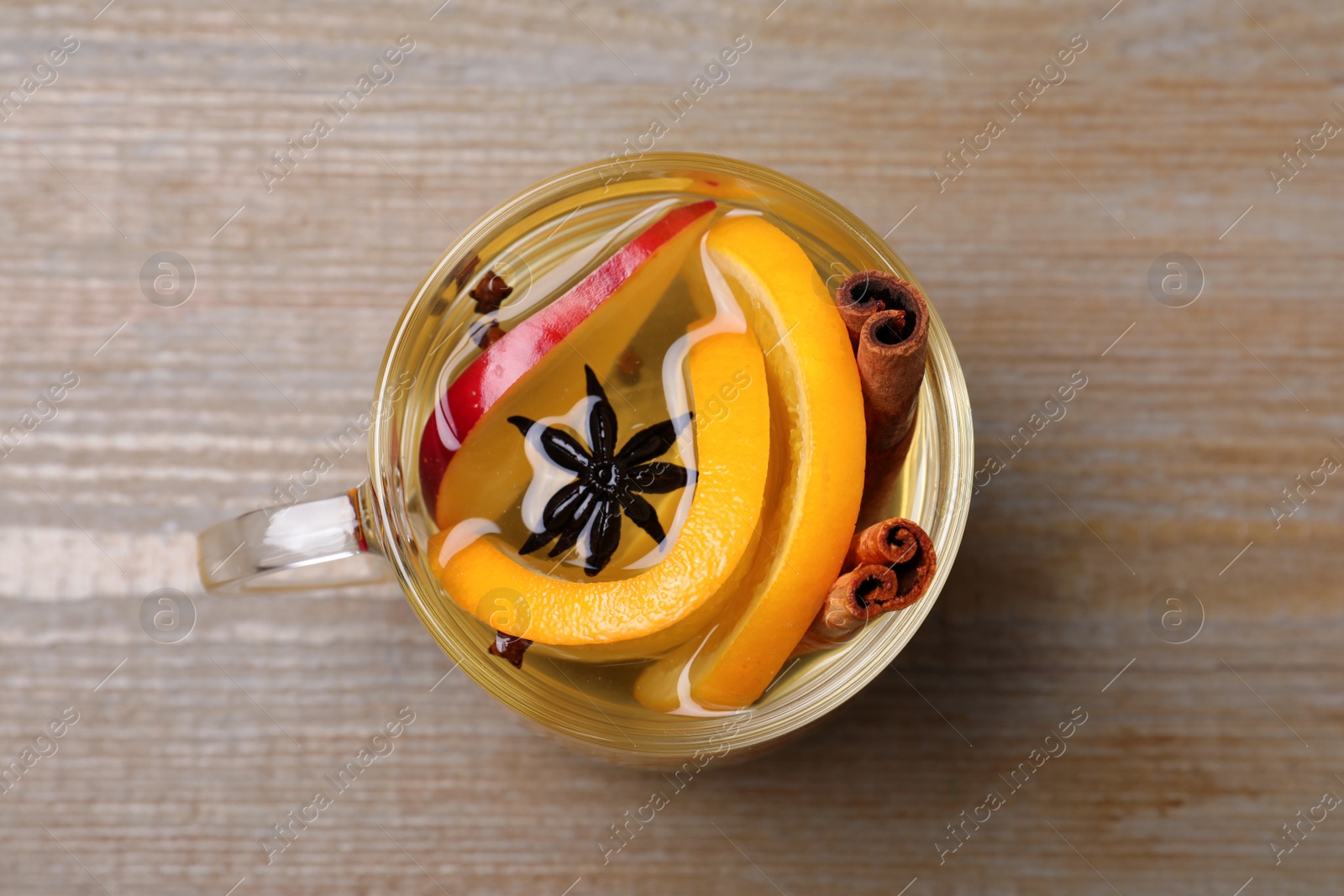 Photo of Aromatic mulled wine on wooden table, top view