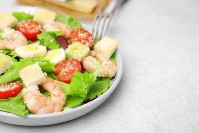 Photo of Delicious Caesar salad with shrimps on light table, closeup. Space for text