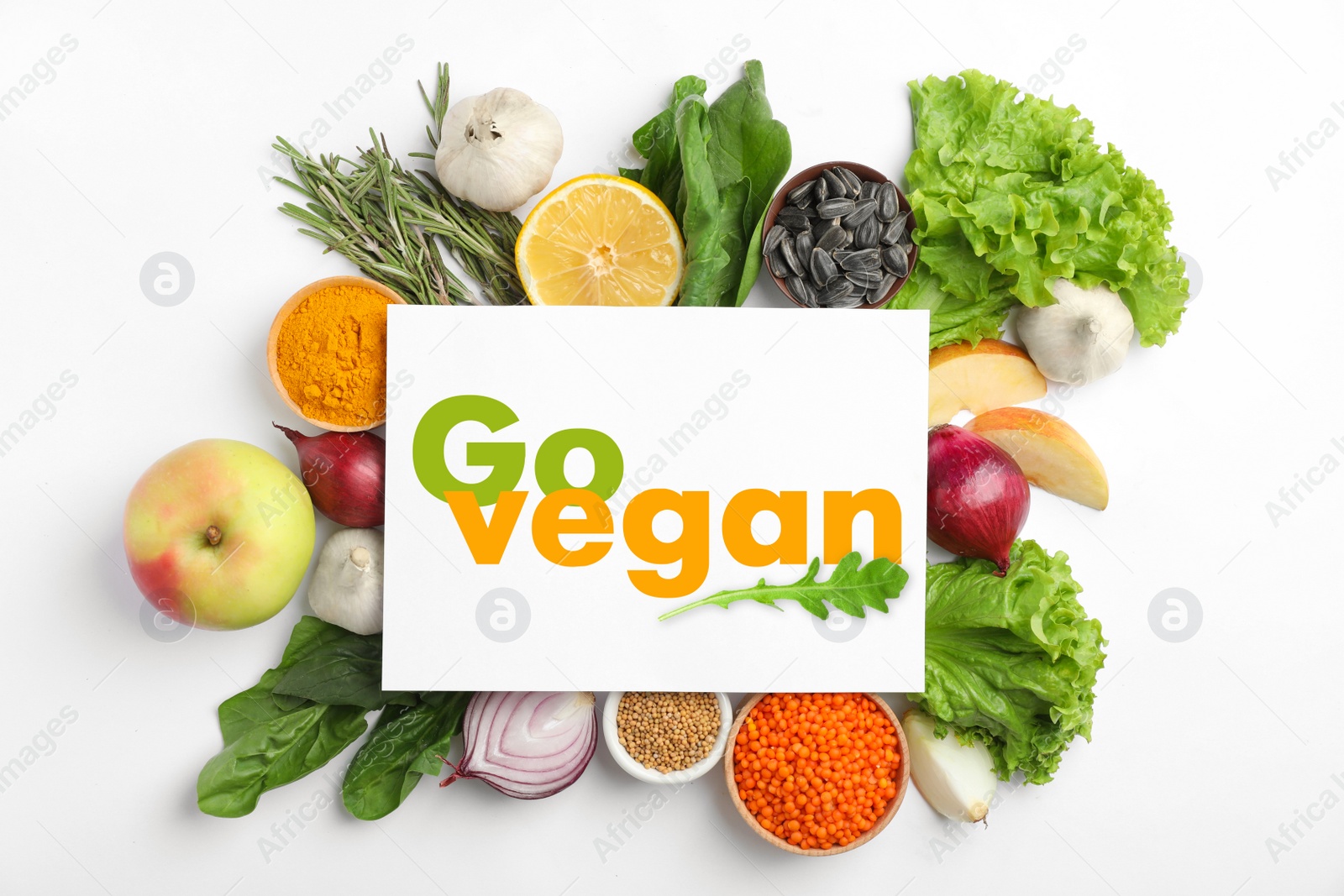 Image of Paper card with phrase Go Vegan and fresh products on white background, flat lay