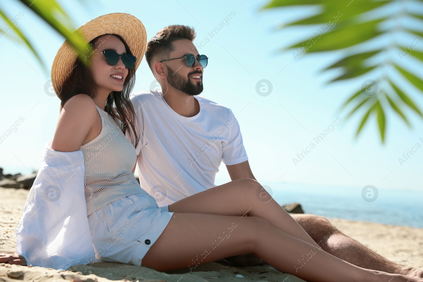 Photo of Happy young couple on beach near sea. Honeymoon trip