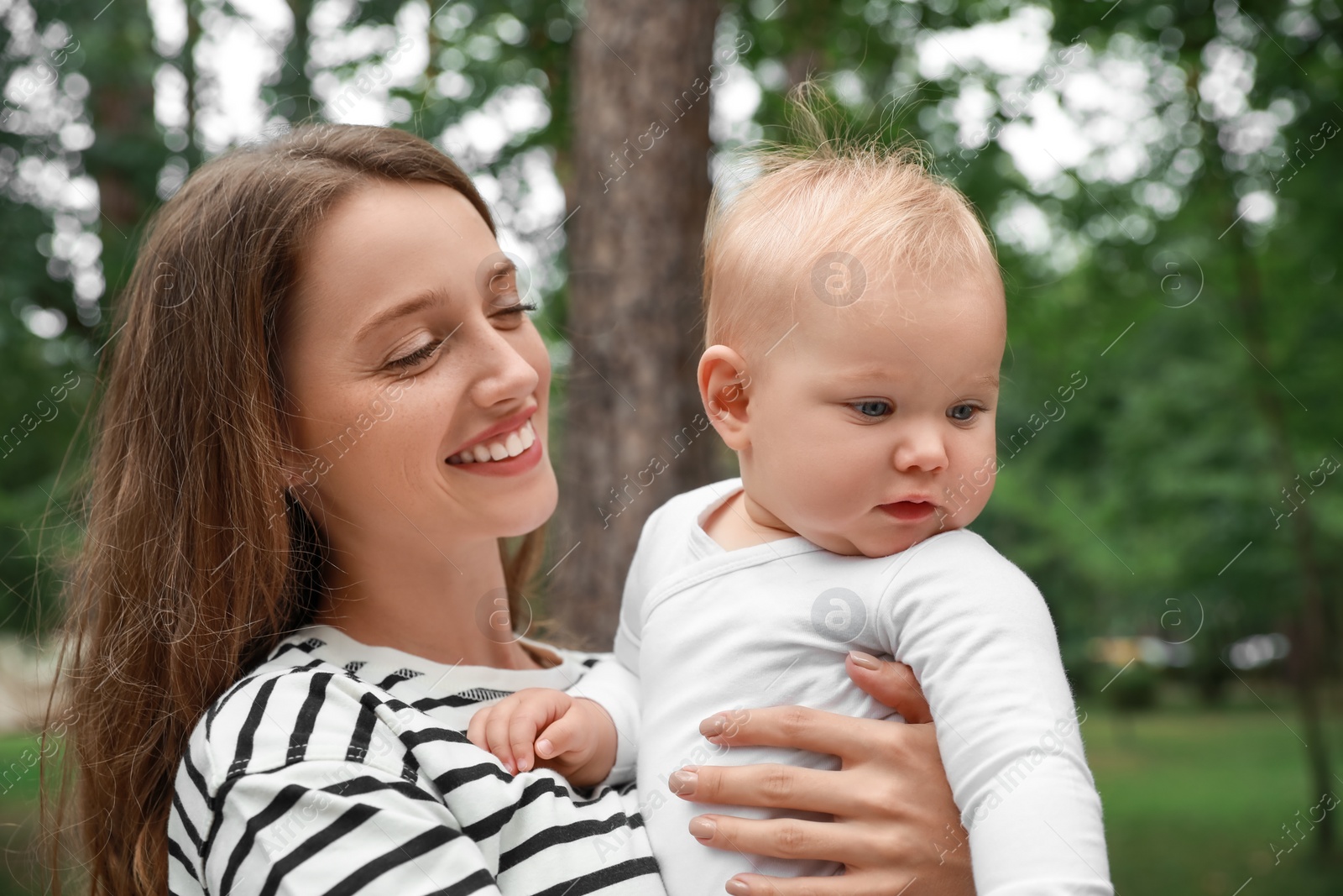 Photo of Mother with her cute baby spending time together outdoors