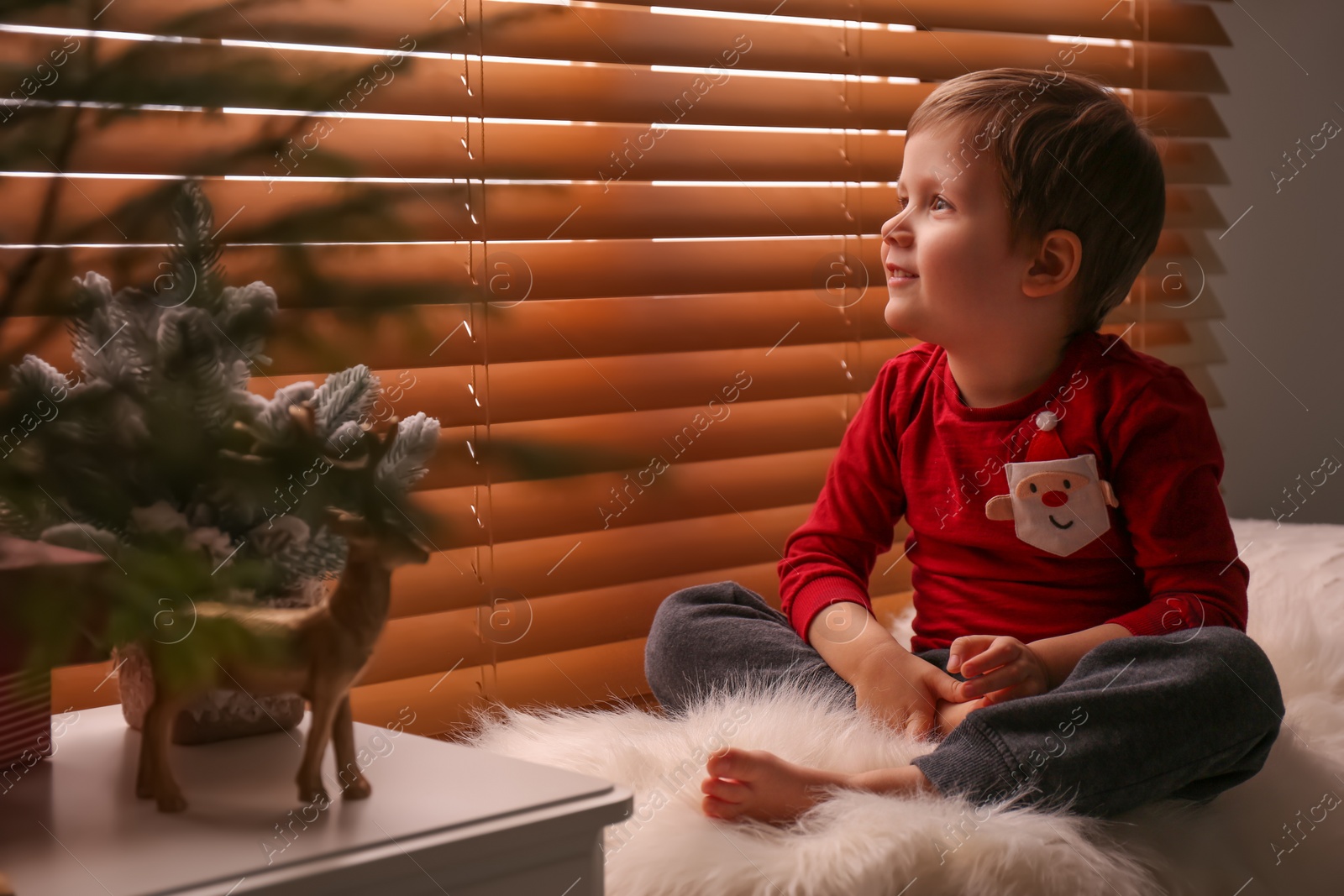 Photo of Cute little boy near window at home. Christmas atmosphere