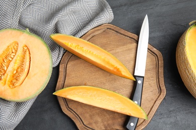 Photo of Tasty fresh melons on black table, flat lay