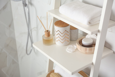 Photo of Shelving unit with different items in bathroom interior