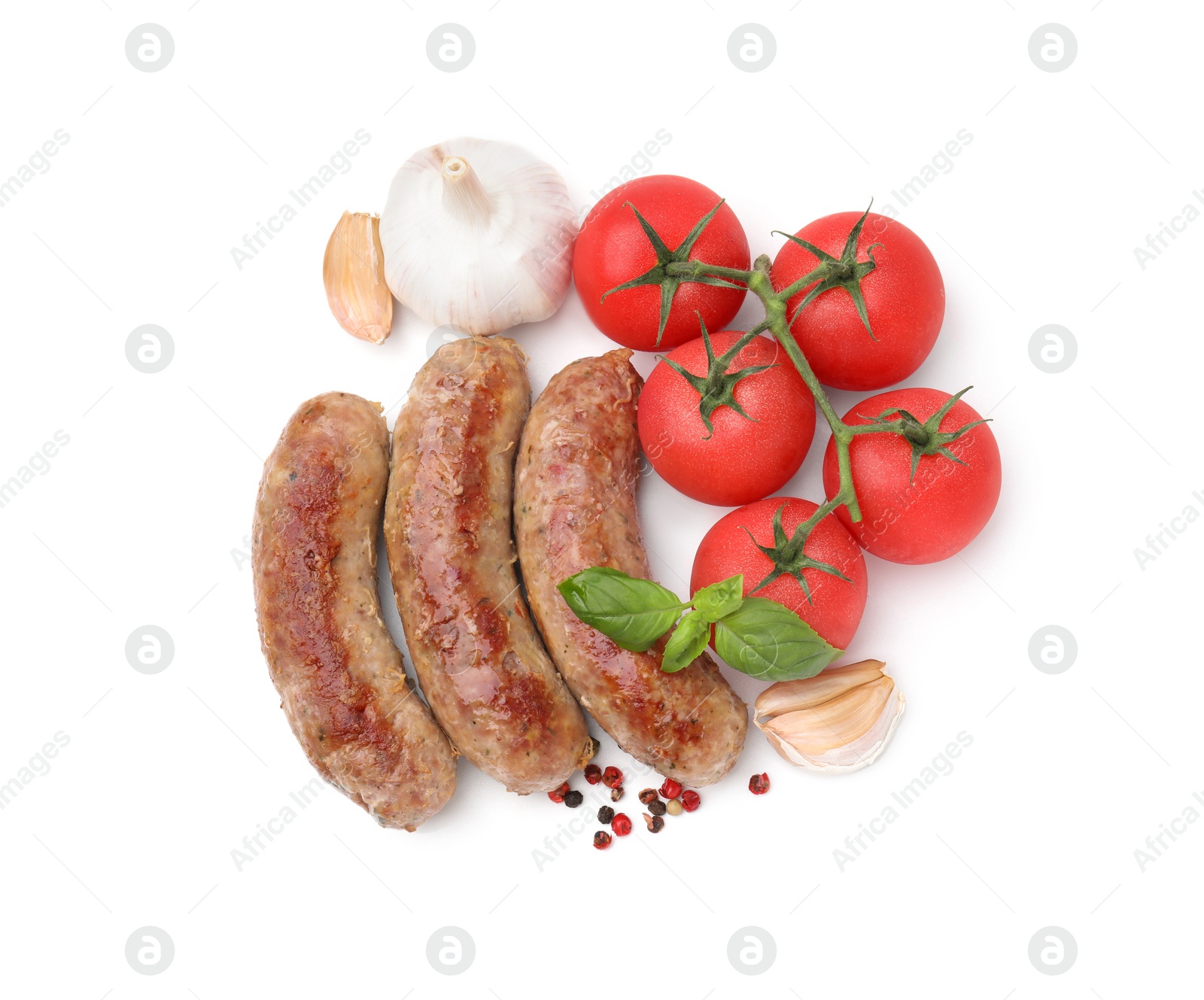 Photo of Tasty homemade sausages, peppercorns, tomatoes, garlic and basil leaves isolated on white, top view