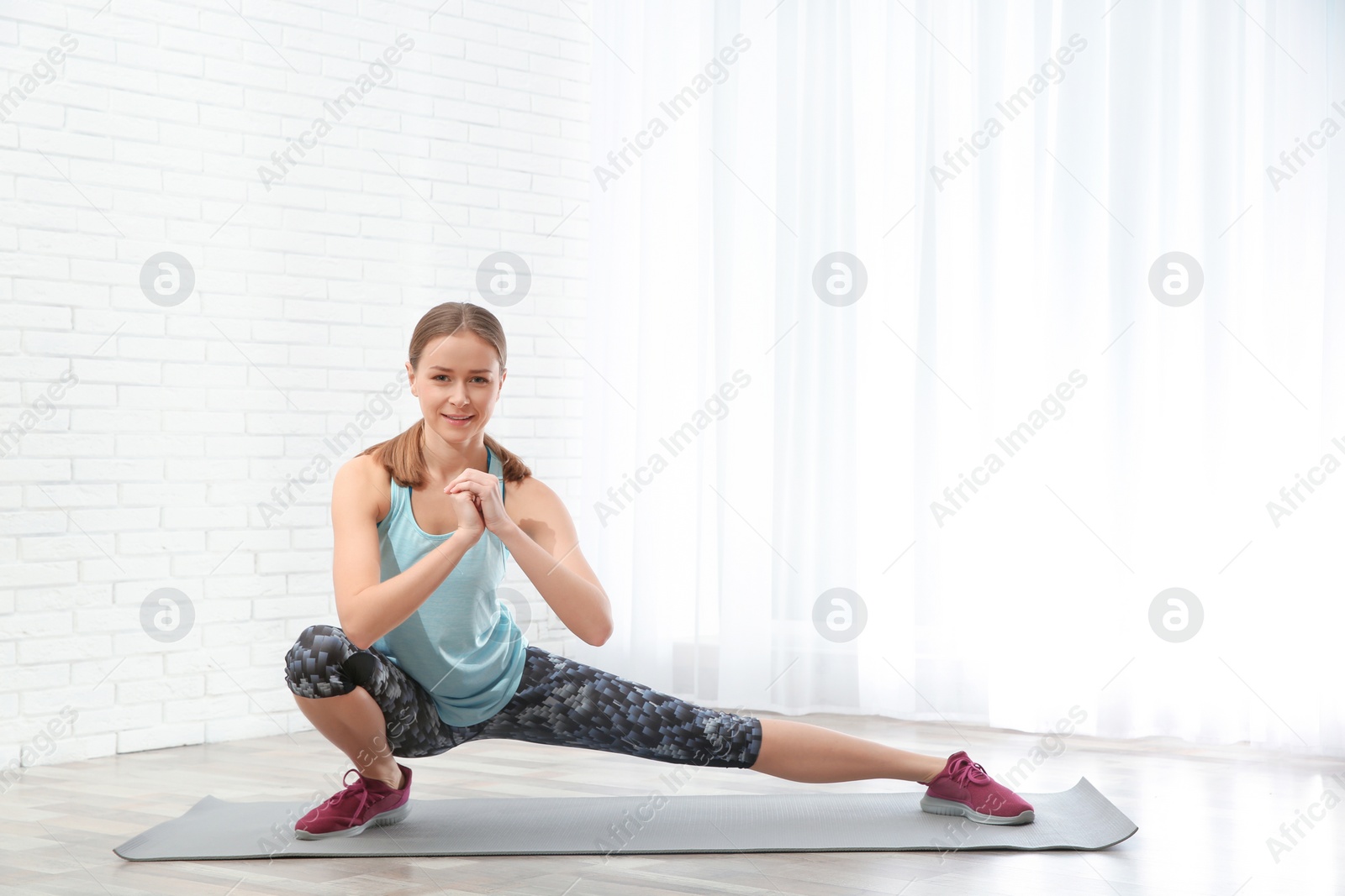 Photo of Young woman doing fitness exercises at home