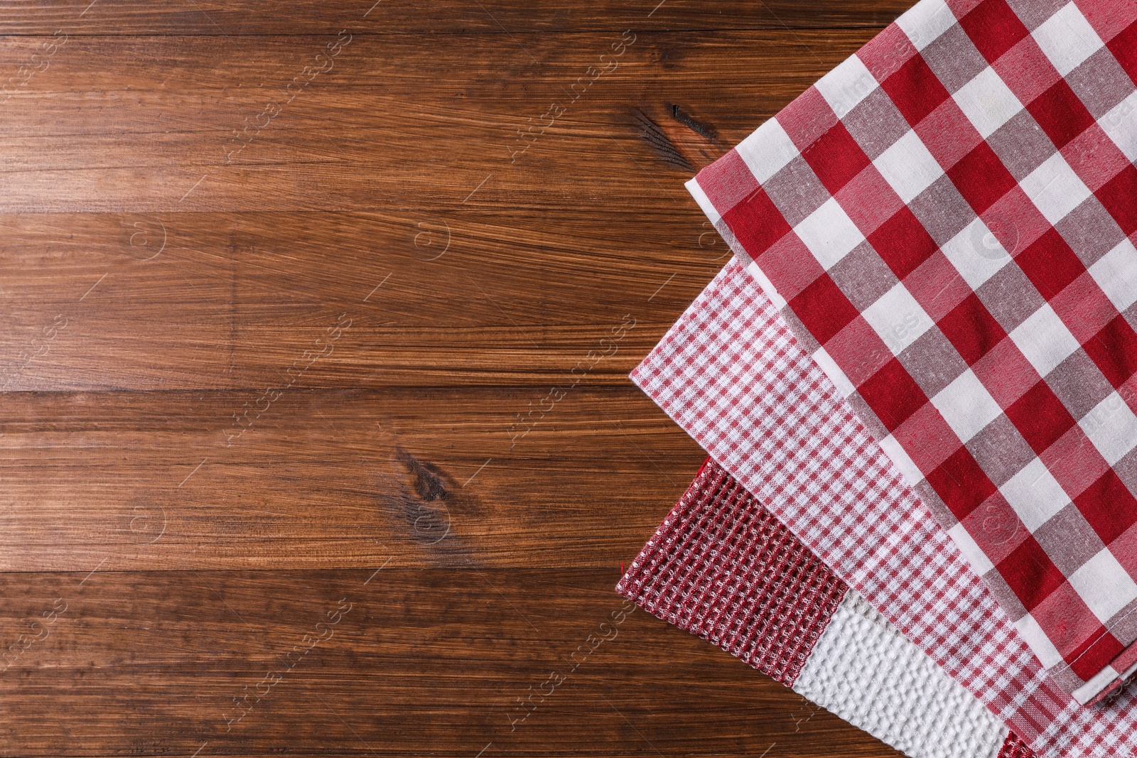 Photo of Different kitchen towels on wooden table, flat lay. Space for text