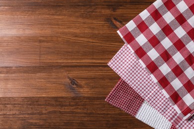 Different kitchen towels on wooden table, flat lay. Space for text