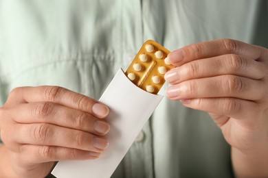 Photo of Woman holding blister of oral contraceptive pills, closeup