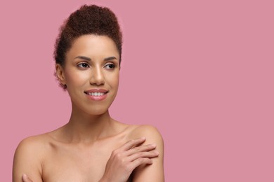 Photo of Portrait of beautiful young woman with glamorous makeup on pink background. Space for text