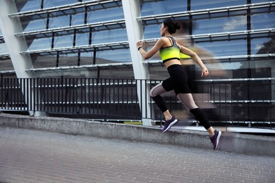 Image of Sporty young woman running on street. Motion blur effect showing her speed