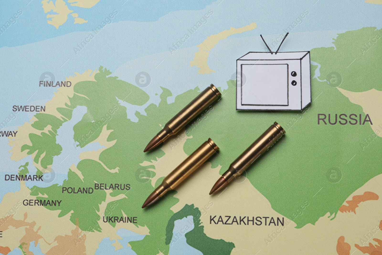 Photo of Paper TV and bullets on world map, flat lay. Hybrid warfare concept