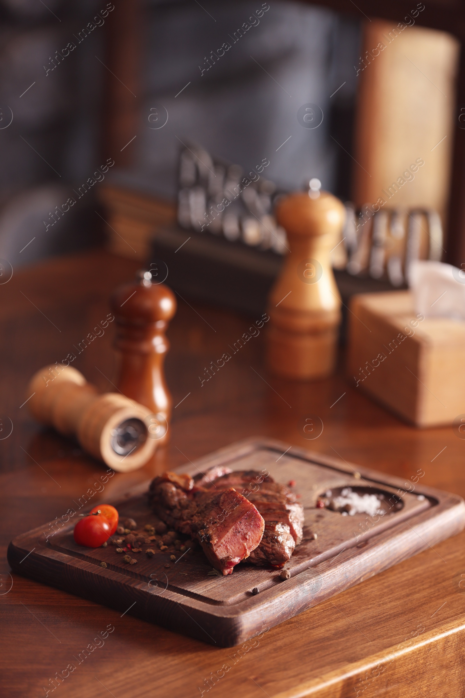 Photo of Tasty roasted meat served on wooden table. Cooking food