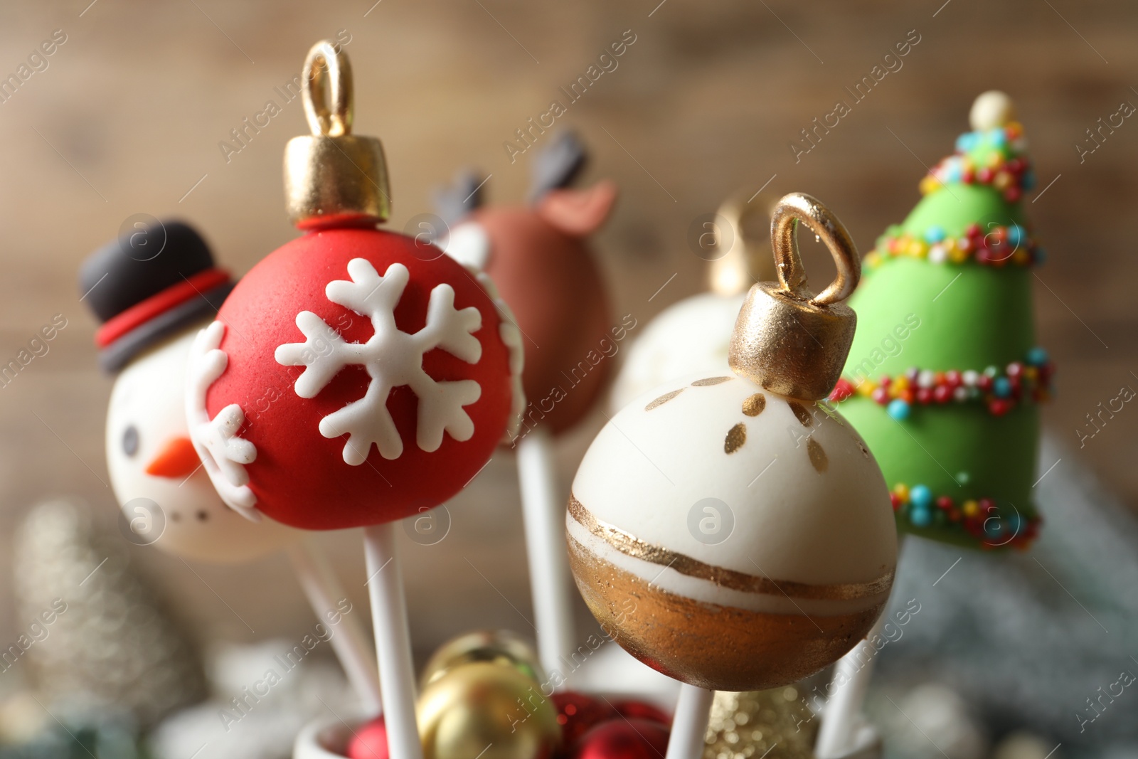 Photo of Delicious Christmas themed cake pops on blurred background, closeup