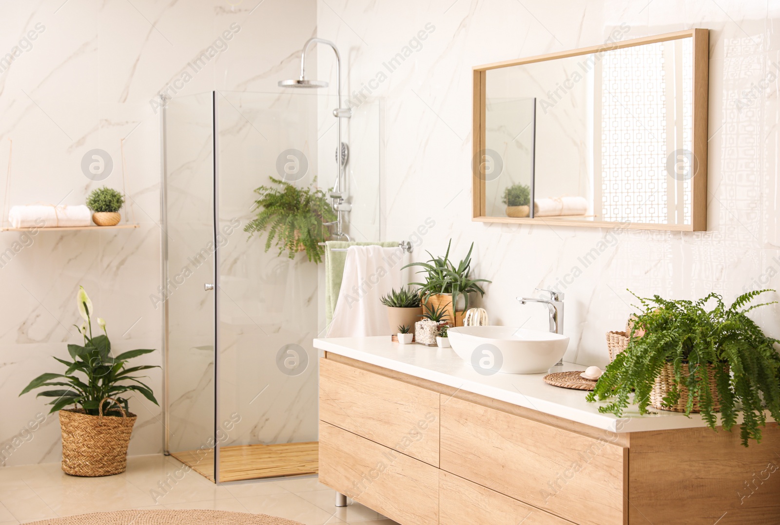 Photo of Stylish bathroom interior with countertop, shower stall and houseplants. Design idea