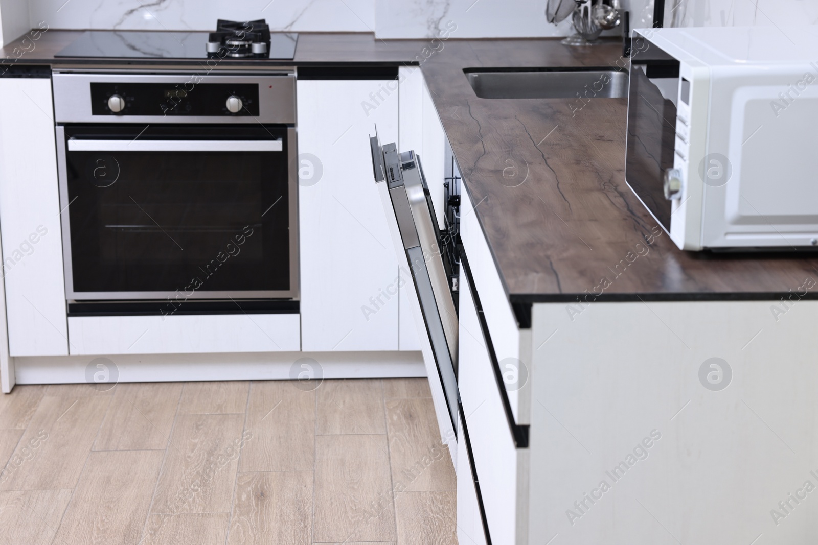 Photo of Built-in dishwasher with open door in kitchen