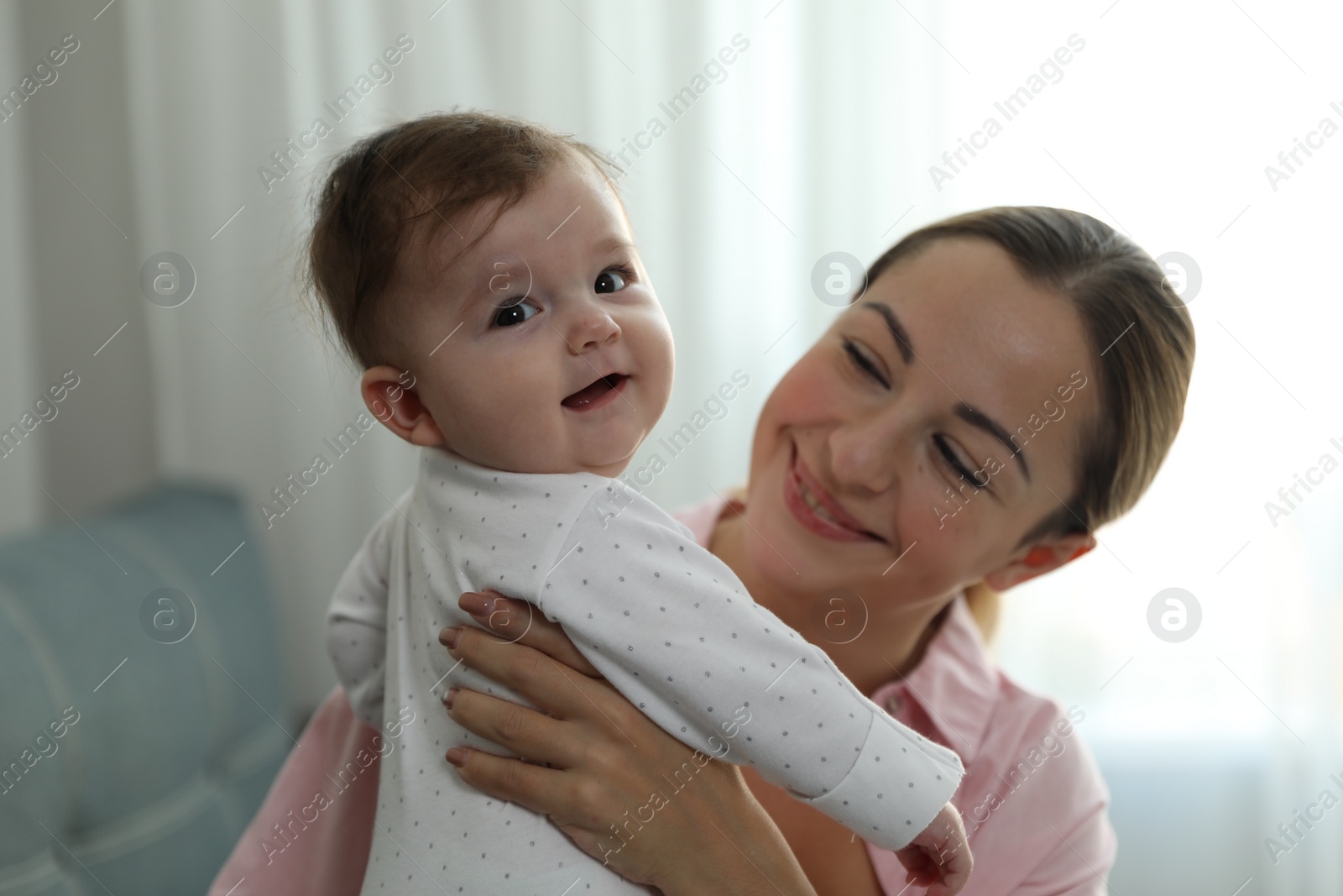 Photo of Young woman with her cute baby at home