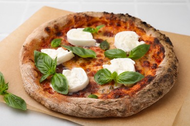 Photo of Delicious pizza with burrata cheese and basil on white table, closeup