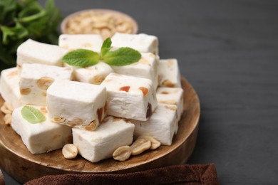 Pieces of delicious nutty nougat on wooden board, closeup