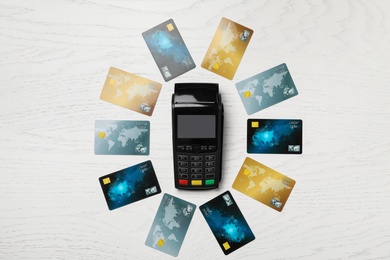 Flat lay composition with credit cards and payment terminal on white wooden background