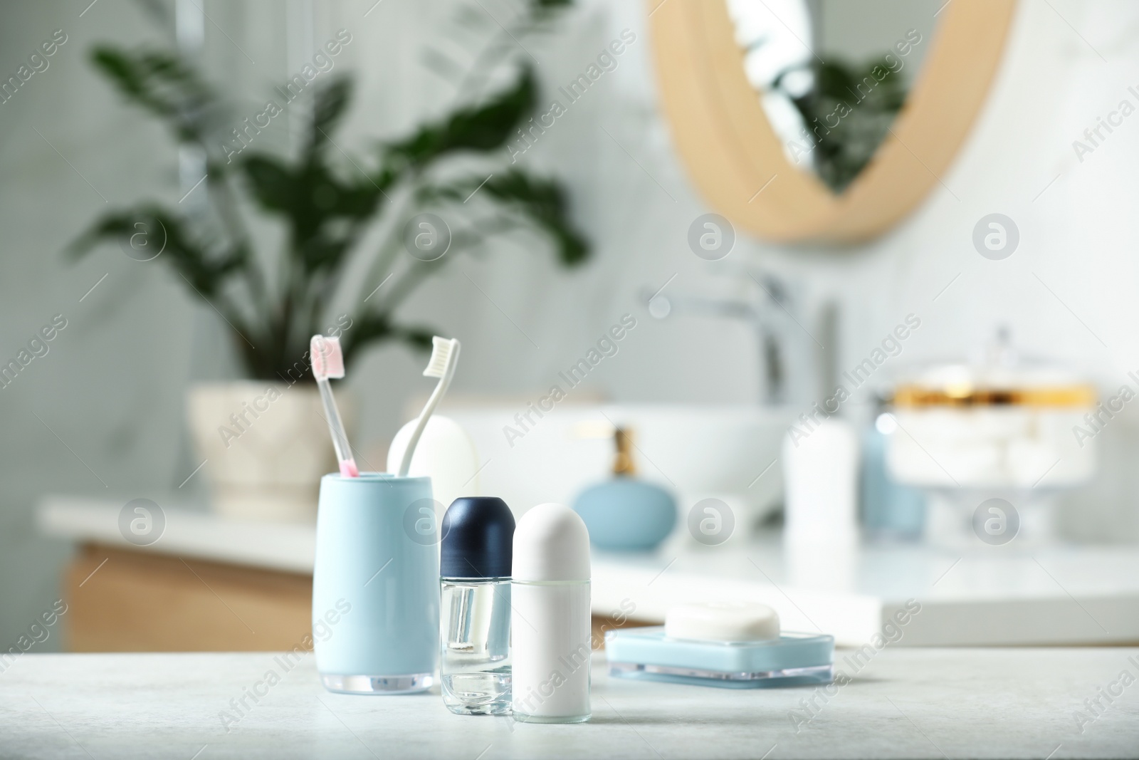 Photo of Roll-on deodorants with toiletry on table in bathroom, space for text