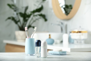 Photo of Roll-on deodorants with toiletry on table in bathroom, space for text