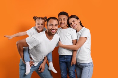 Photo of Happy international family with children on orange background