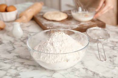 Photo of Bowl with flour and woman on background