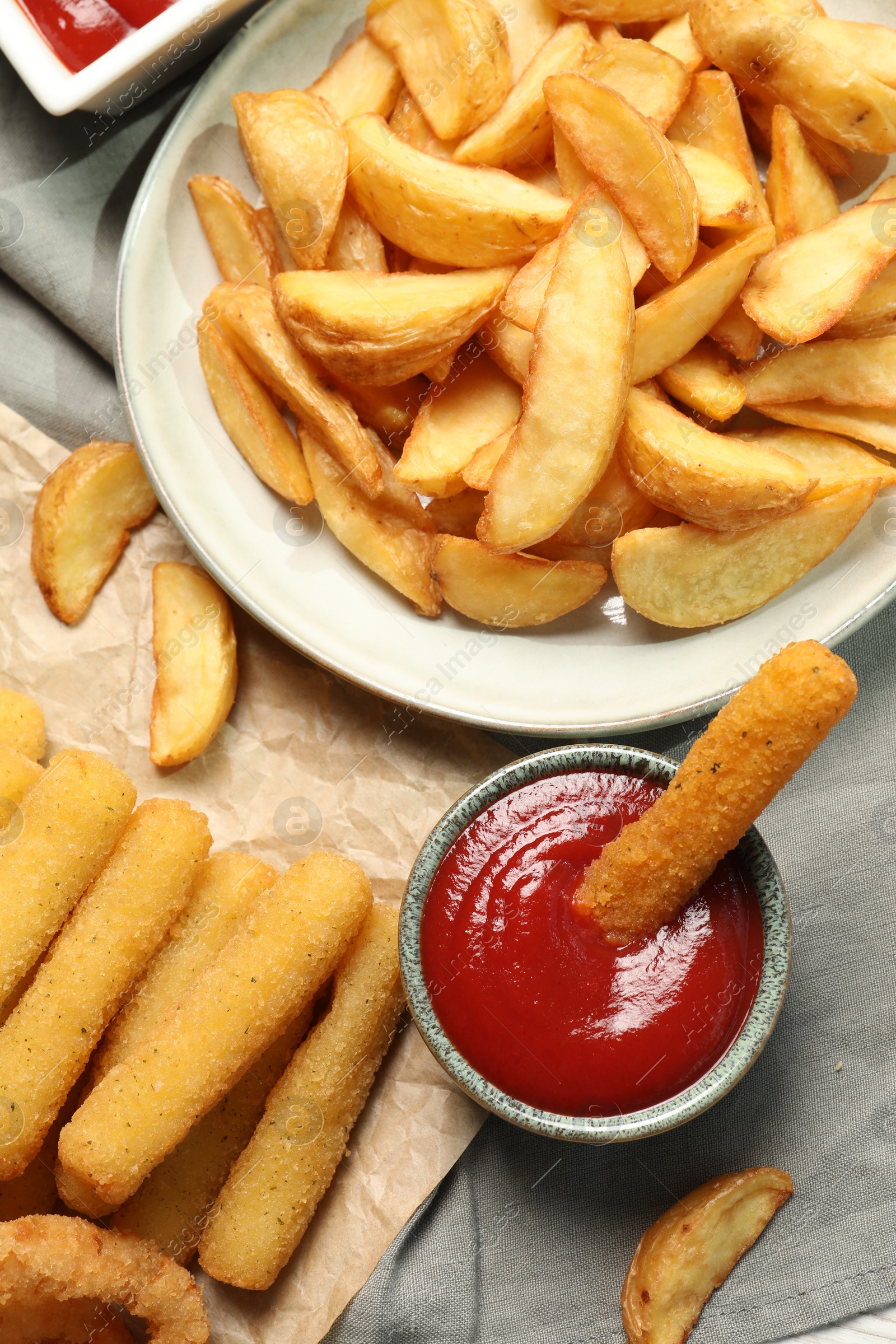 Photo of Different snacks and tasty ketchup on table, flat lay