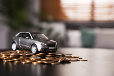 Miniature automobile model and money on table indoors, space for text. Car buying