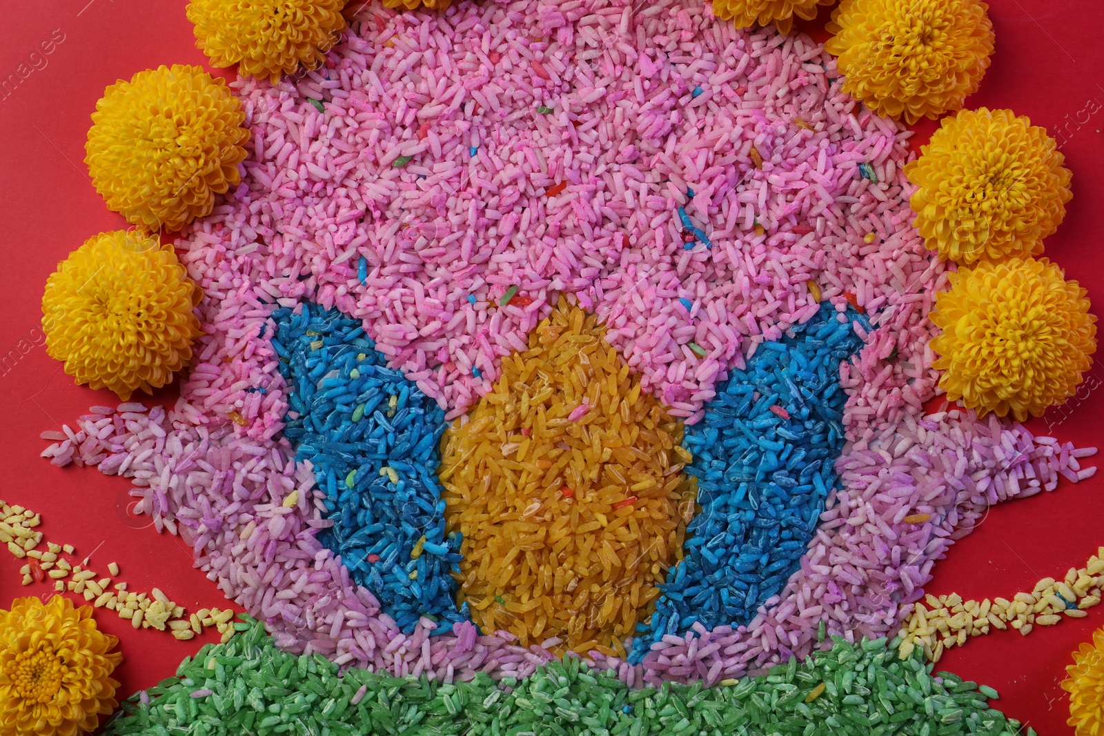 Photo of Happy Diwali. Composition with colorful rangoli and chrysanthemum flowers on red background, top view