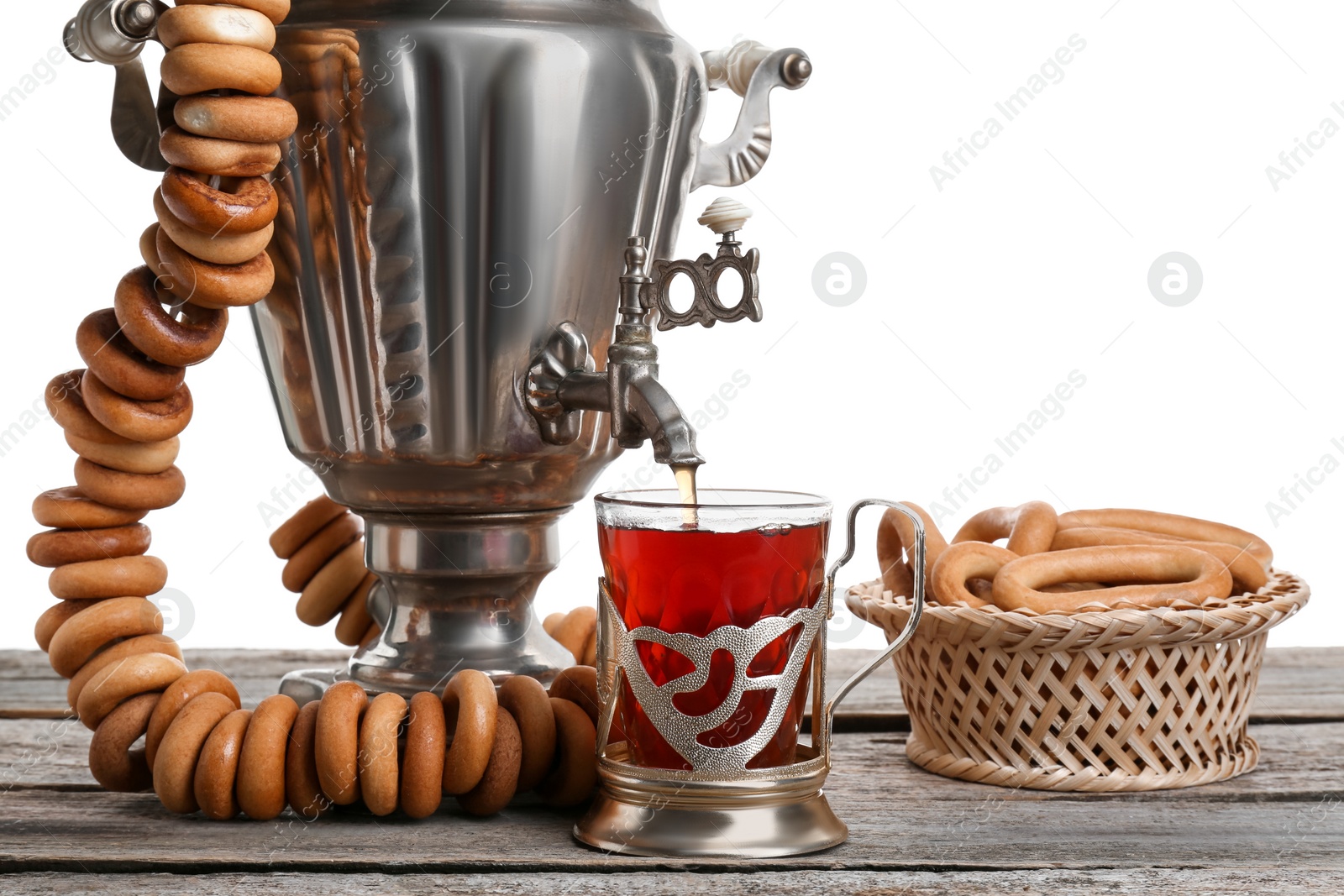 Photo of Samovar with hot tea, jam and delicious ring shaped Sushki (dry bagels) on table against white background