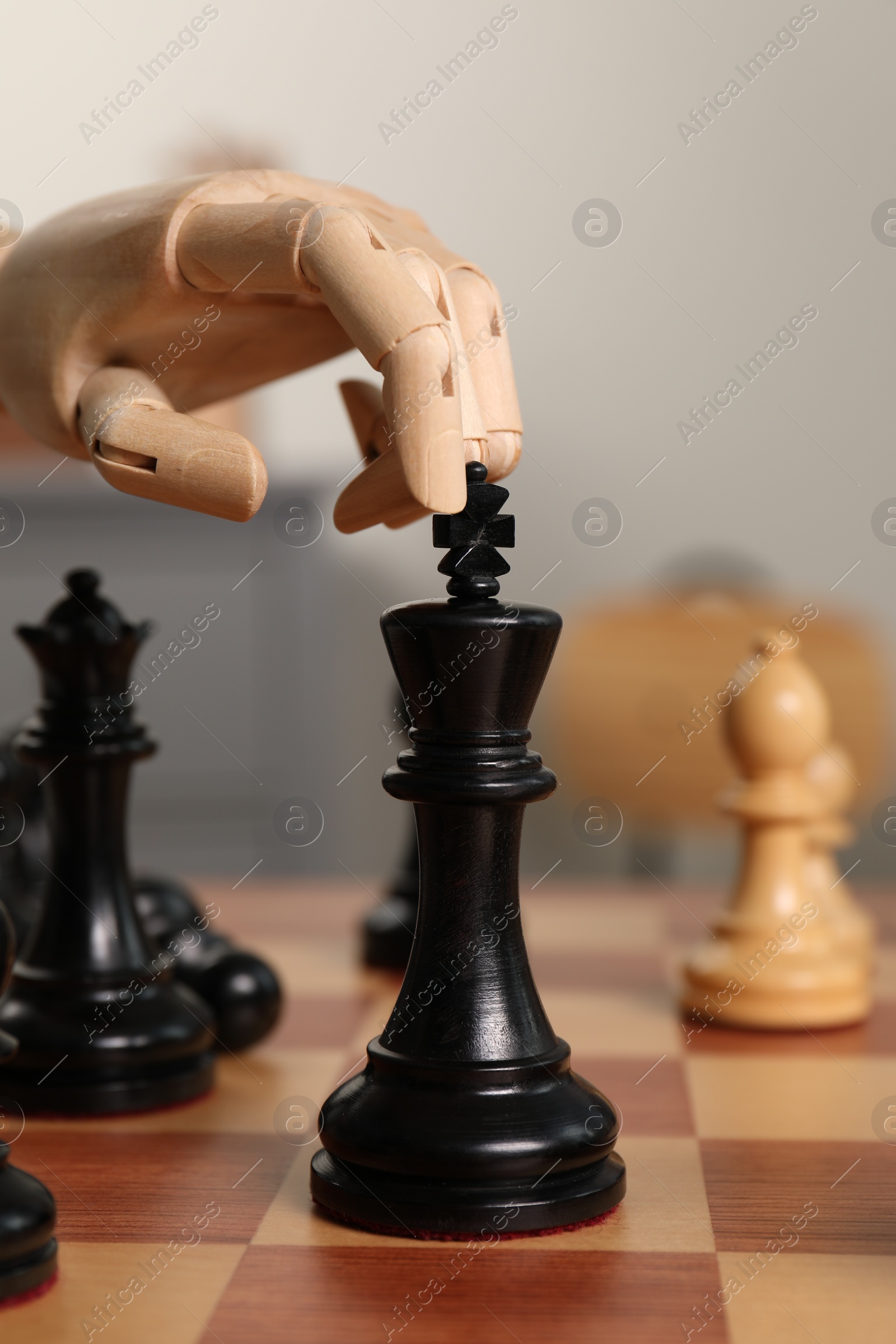 Photo of Robot moving chess piece on board, closeup. Wooden hand representing artificial intelligence