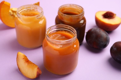 Photo of Healthy baby food and ingredients on violet background