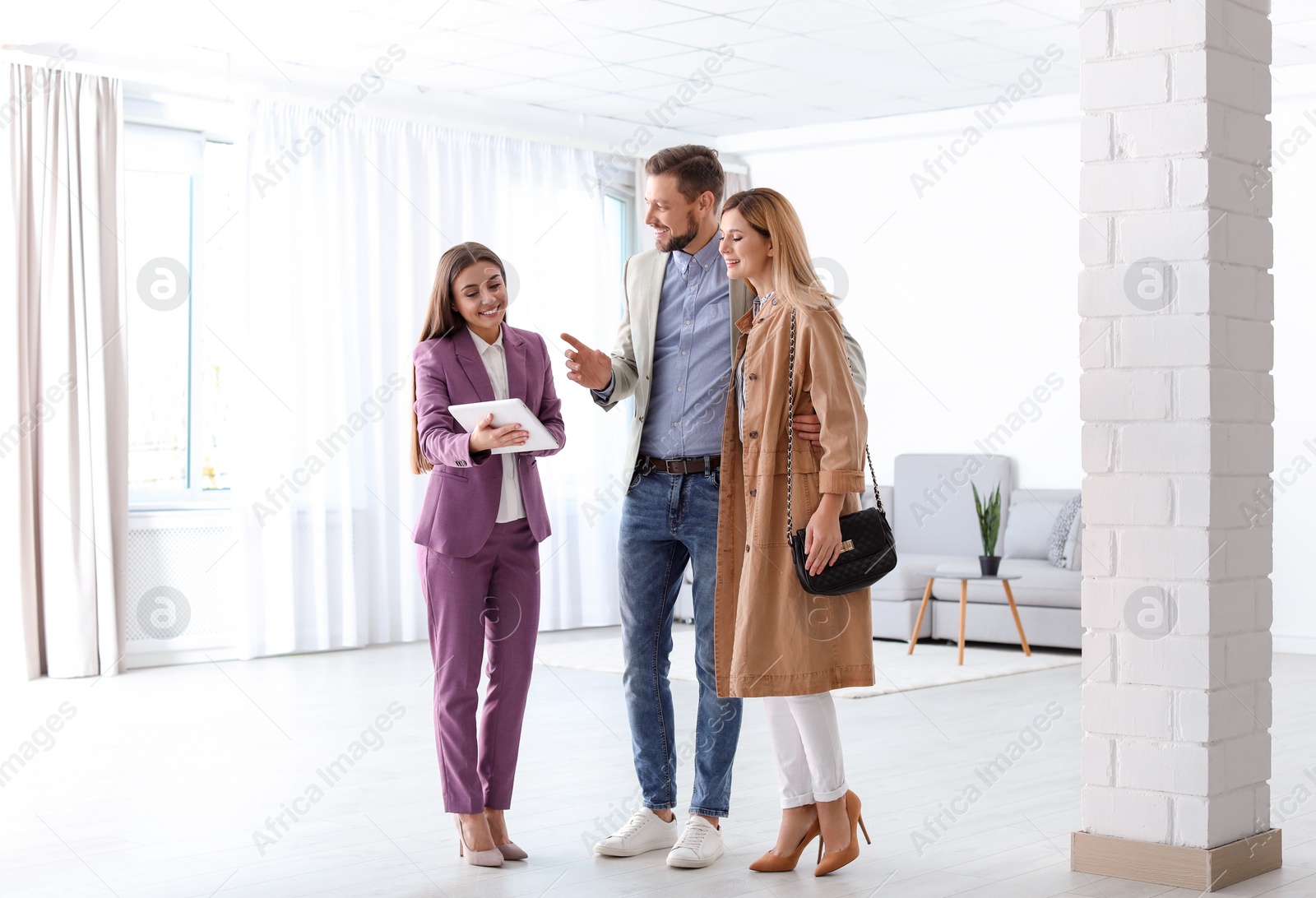 Photo of Female real estate agent working with couple in room
